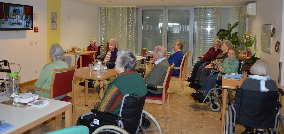 Bewohnerinnen schauen die Hl. Messe per Videoübertragung.