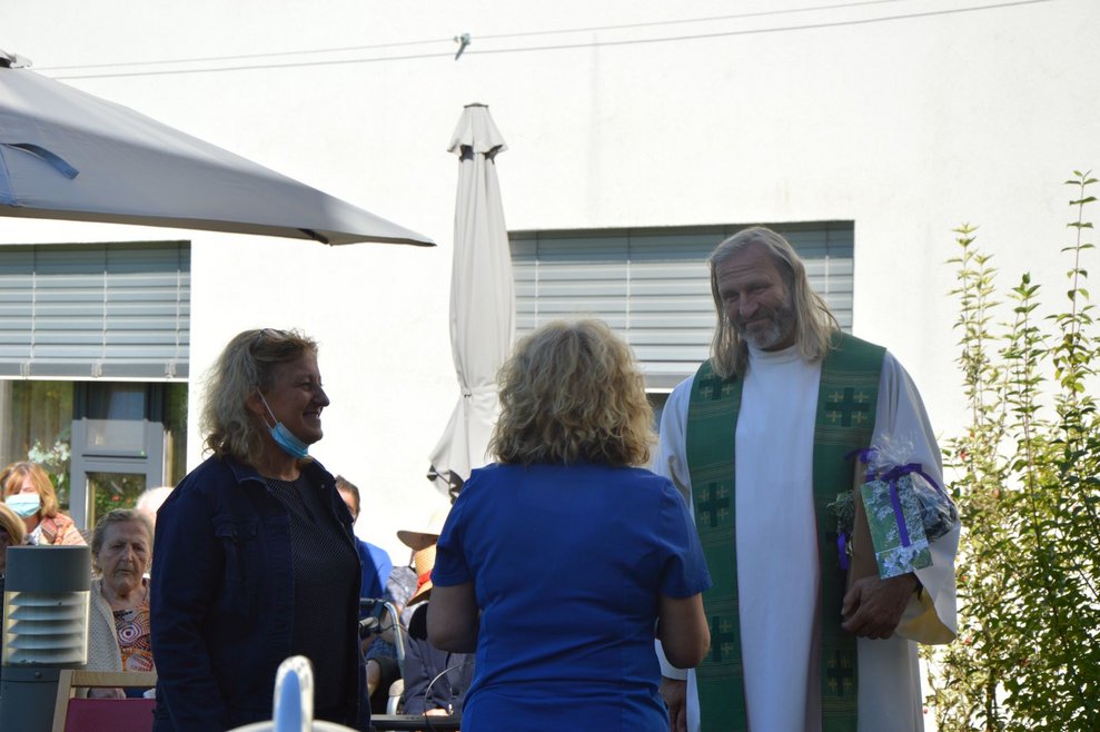 Zwei Frauen stehen beim Pfarrer