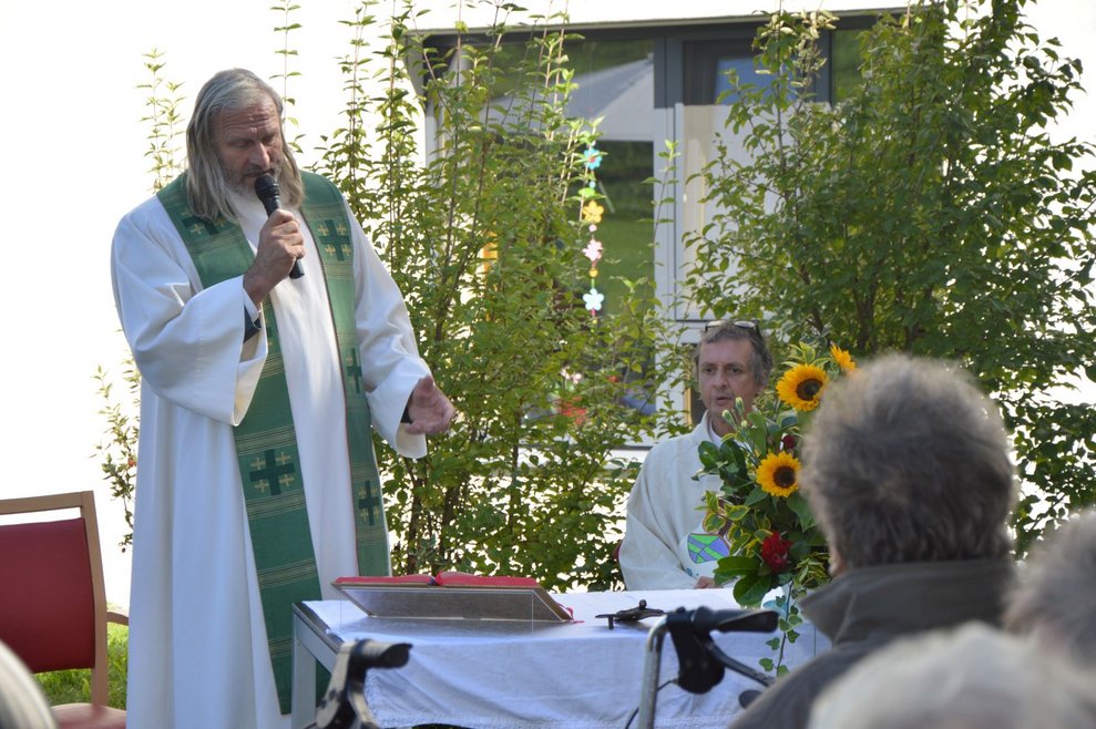 Pfarrer spricht zu BewohnerInnen