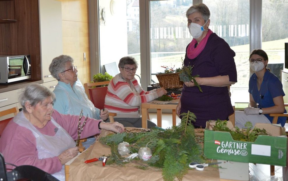 Bewohnerinnen binden Palmbüsche