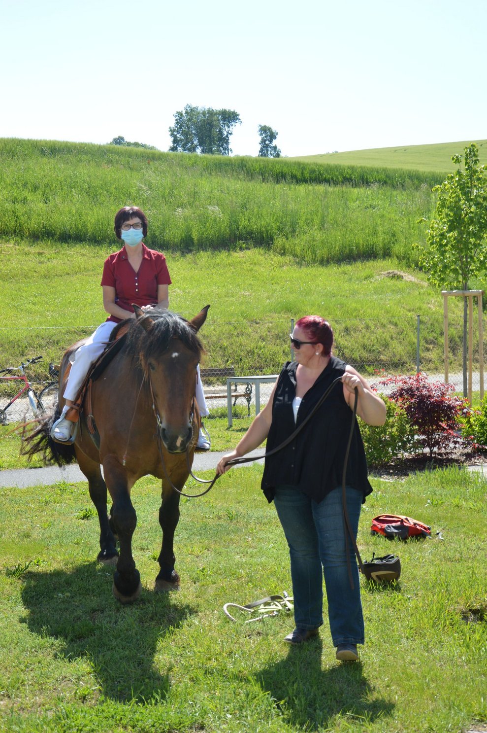 Mitarbeiterin sitzt auf Pferd