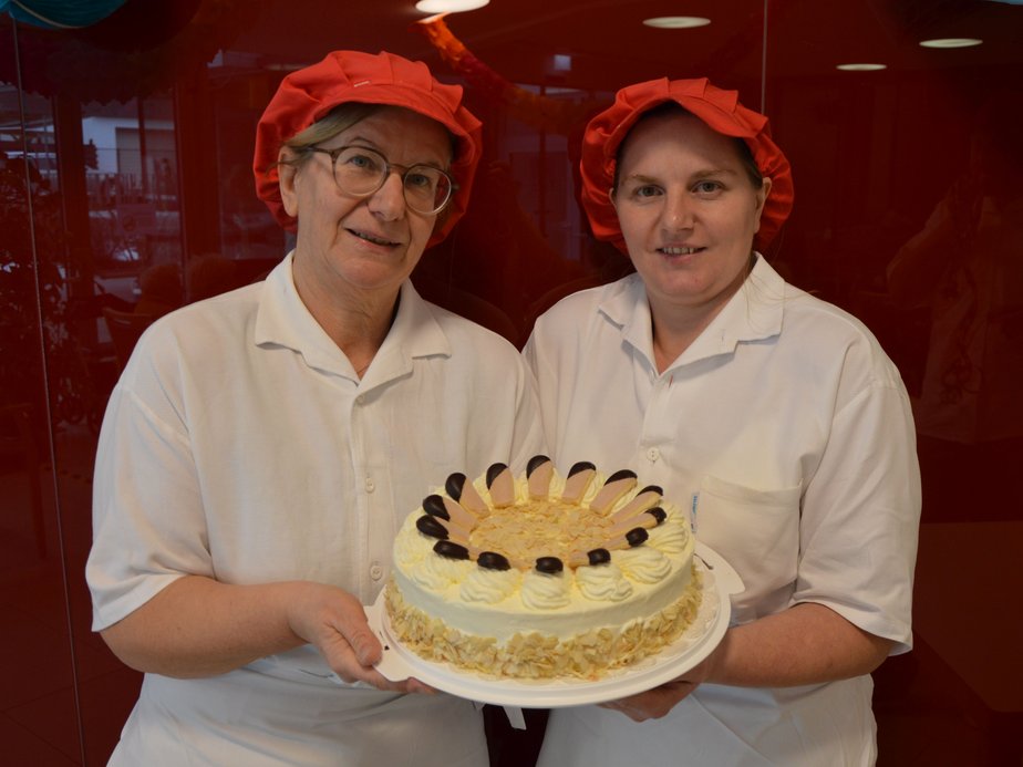 Küchenpersonal hält Torte.