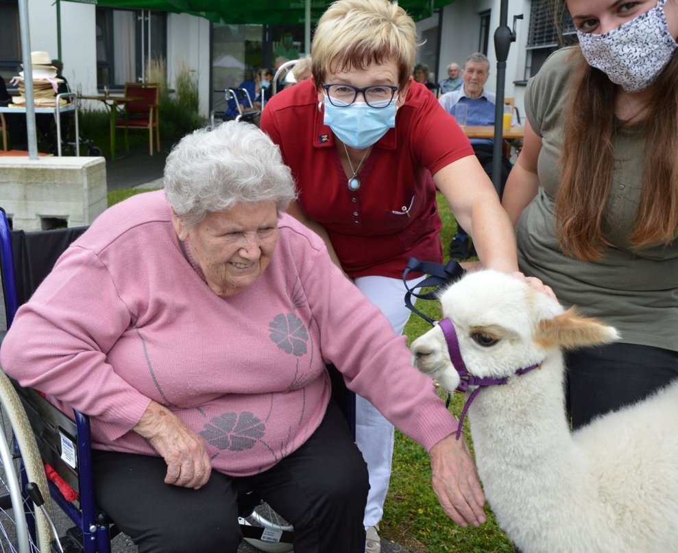 Bewohnerin und Betreuerin mit Alpaka