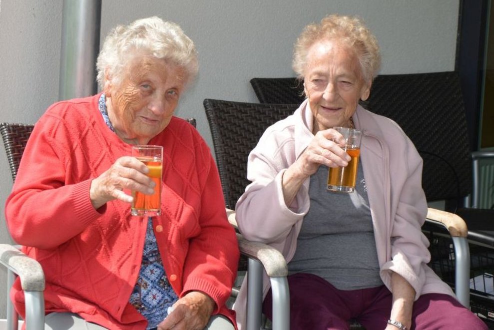 Bewohnerinnen halten Gläser