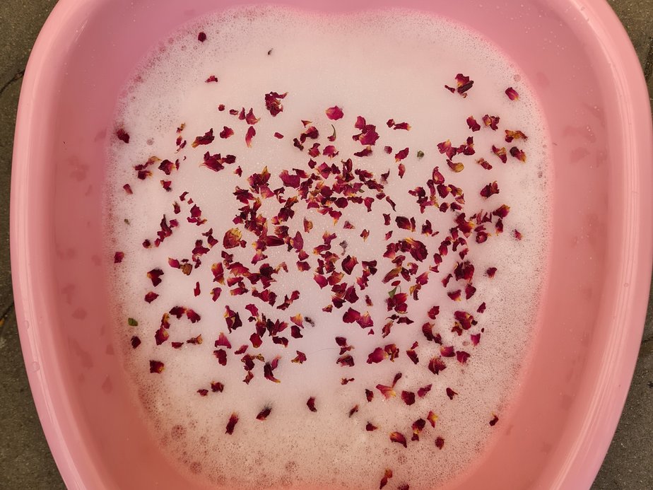 Eine Wanne, die mit Blüten und Schaum gefüllt ist.