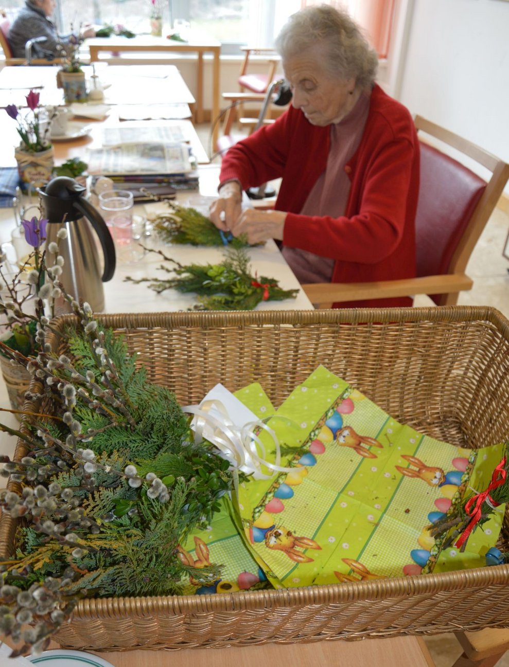 Bewohnerin bindet Palmbesen.