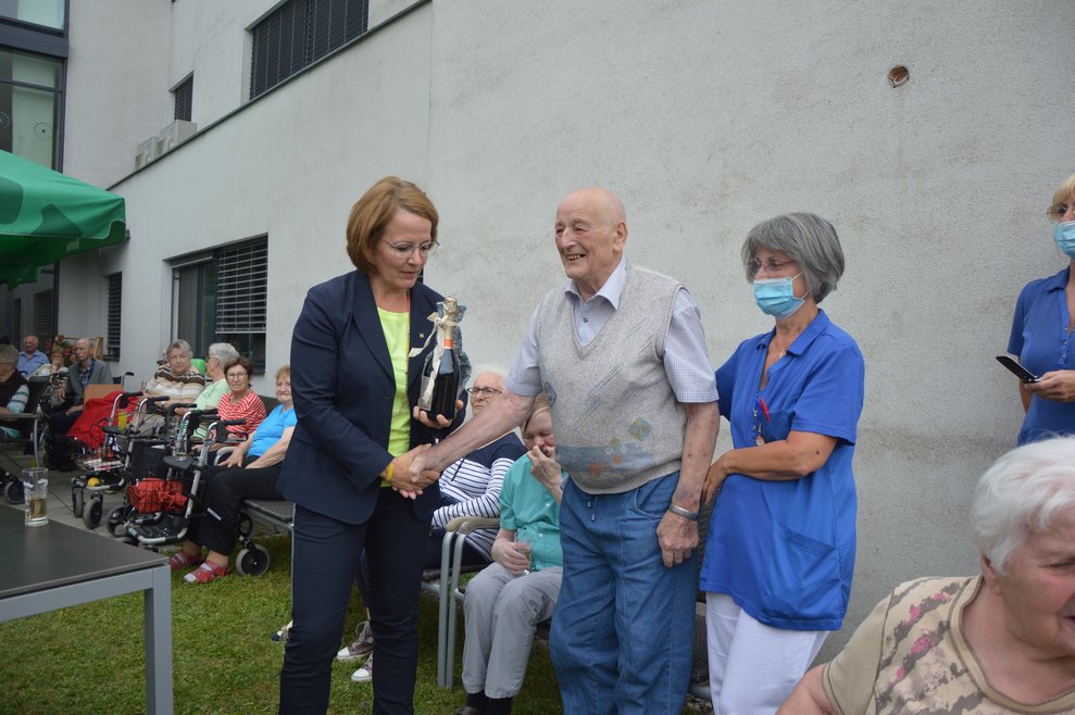Bewohner übergibt Landesrätin Christiane Teschl-Hofmeister ein kleines Geschenk