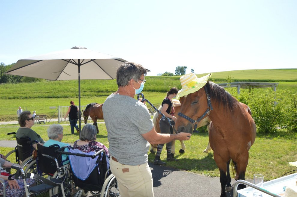 Bewohnerin streichelt Pferd