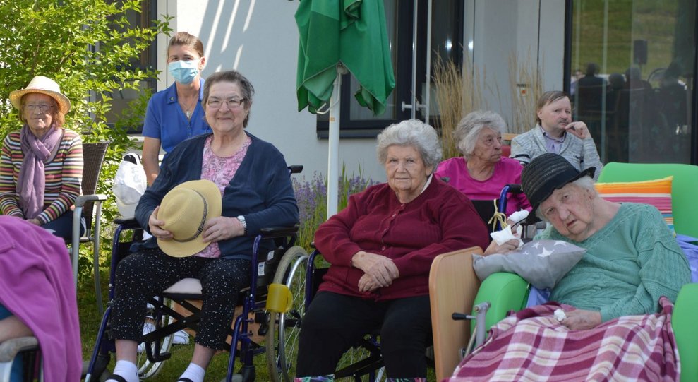 BewohnerInnen sitzen draußen